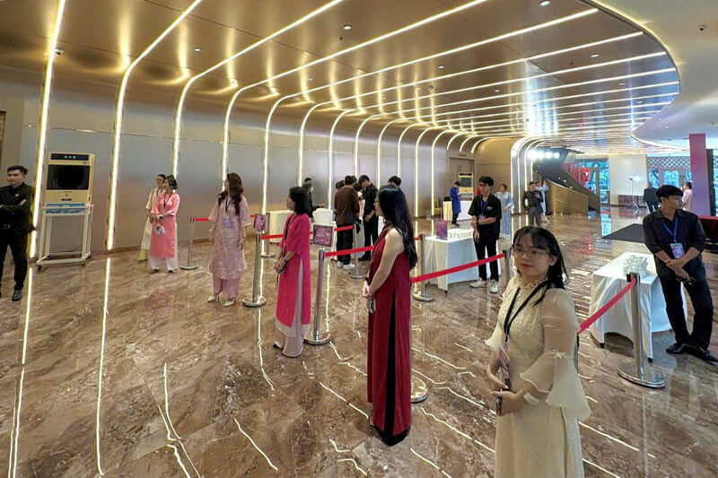 Khách tham dự di chuyển và check in tại khu vực sảnh sự kiện đông người với hệ thống quản lý vào cổng