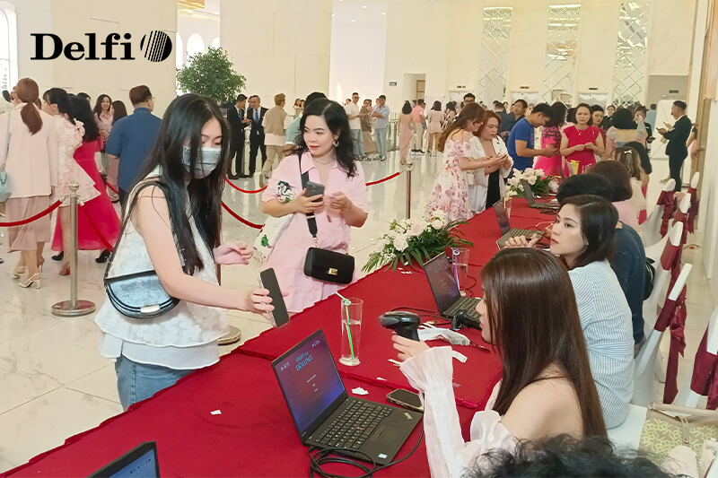 Khách tham dự đang check-in bằng mã QR tại quầy tiếp đón sự kiện New Year Party 2024