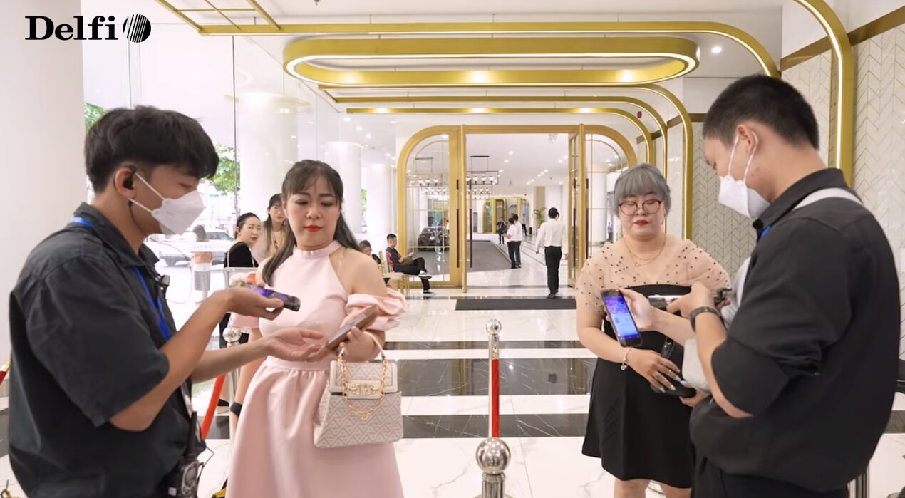 Nhân viên đang quét mã check-in cho khách tại khu vực tiếp đón sự kiện