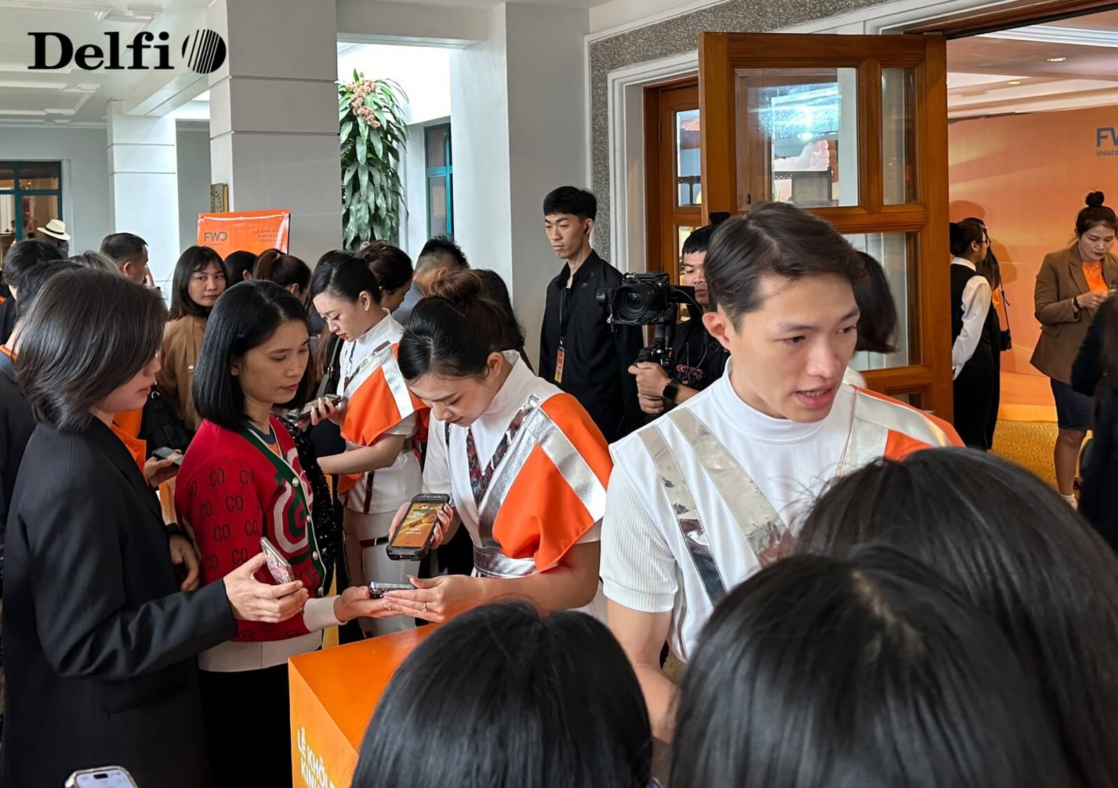 Khách tham dự đang thực hiện check-in bằng mã vạch tại khu vực tiếp đón trong sự kiện.