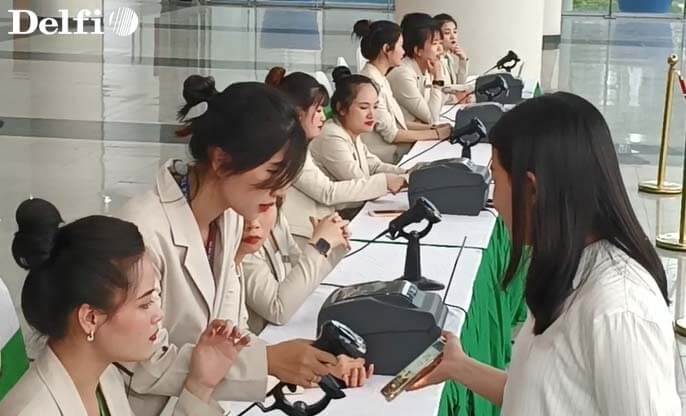 Nhân viên đang hỗ trợ khách đăng ký Check-in tại bàn tiếp đón sự kiện