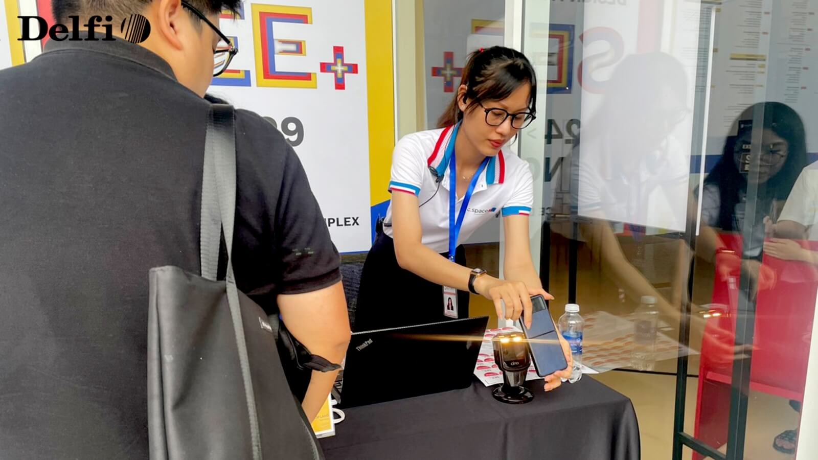 Nhân viên đang hỗ trợ khách check-in tại quầy tiếp đón sự kiện