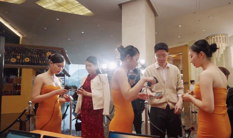 Nhân viên đang hỗ trợ khách check-in bằng điện thoại tại sự kiện