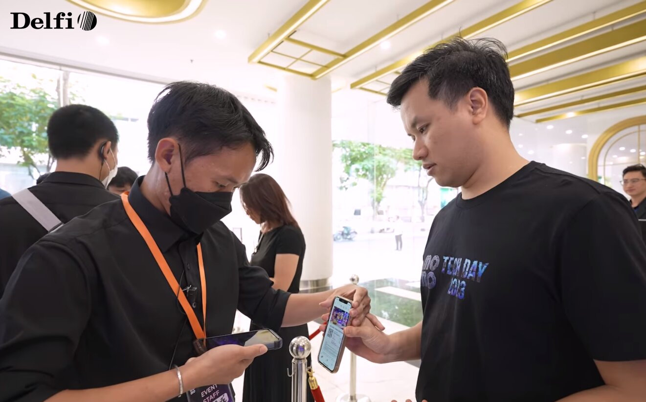 Nhân viên đang quét mã check-in QR từ điện thoại của khách tham dự sự kiện
