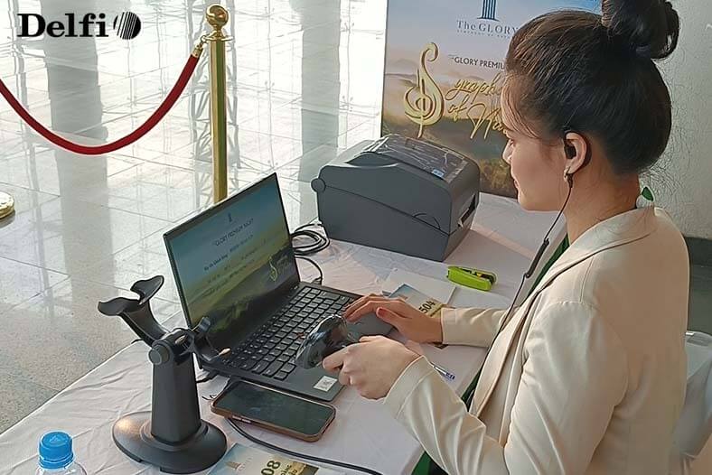 Nhân viên đang hỗ trợ khách quét mã QR Check-in tại khu vực tiếp đón sự kiện