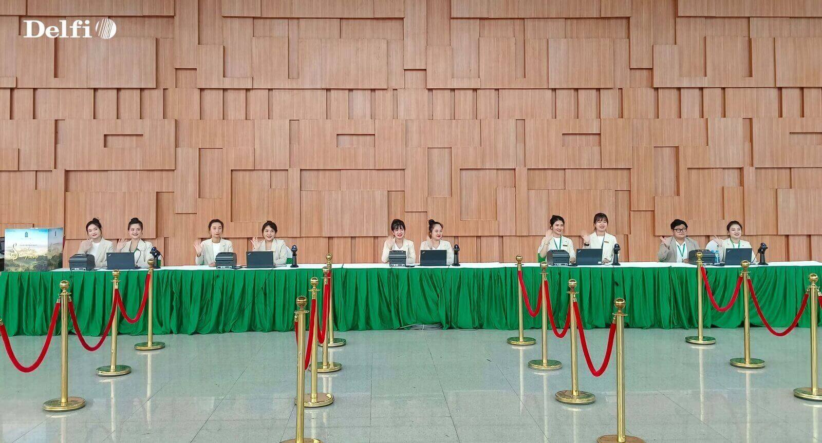 Nhân viên đang Check-in cho khách tại quầy tiếp đón trong khu vực sự kiện