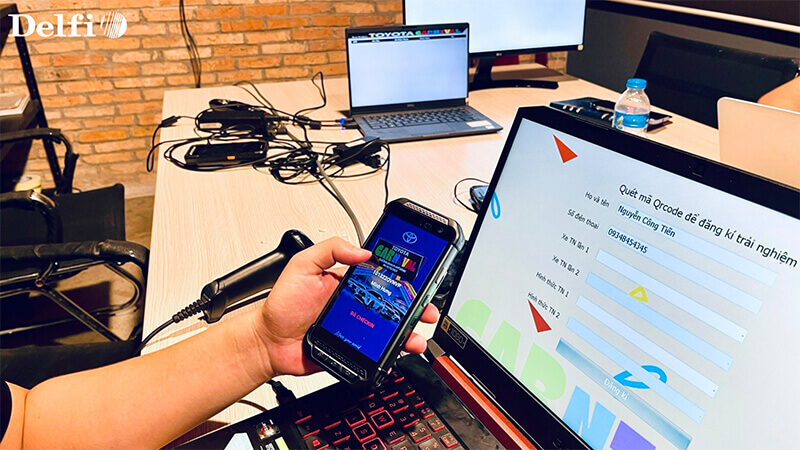 Hệ thống gồm điện thoại và laptop đang hỗ trợ quét mã QR check-in